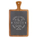 Acacia wood paddle-shaped cheese board with engraved slate, featuring family names and monograms.